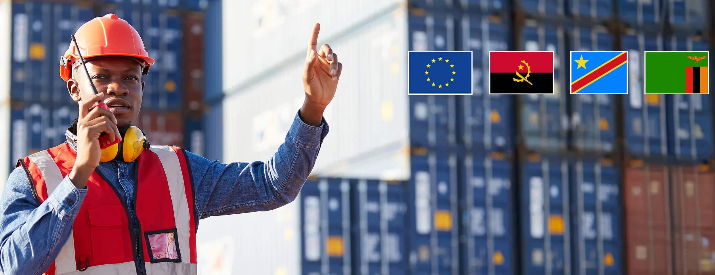 Construction worker in a red safety vest and helmet points upward with stacked shipping containers and five flags eu angola dr congo tanzania zambia in the background