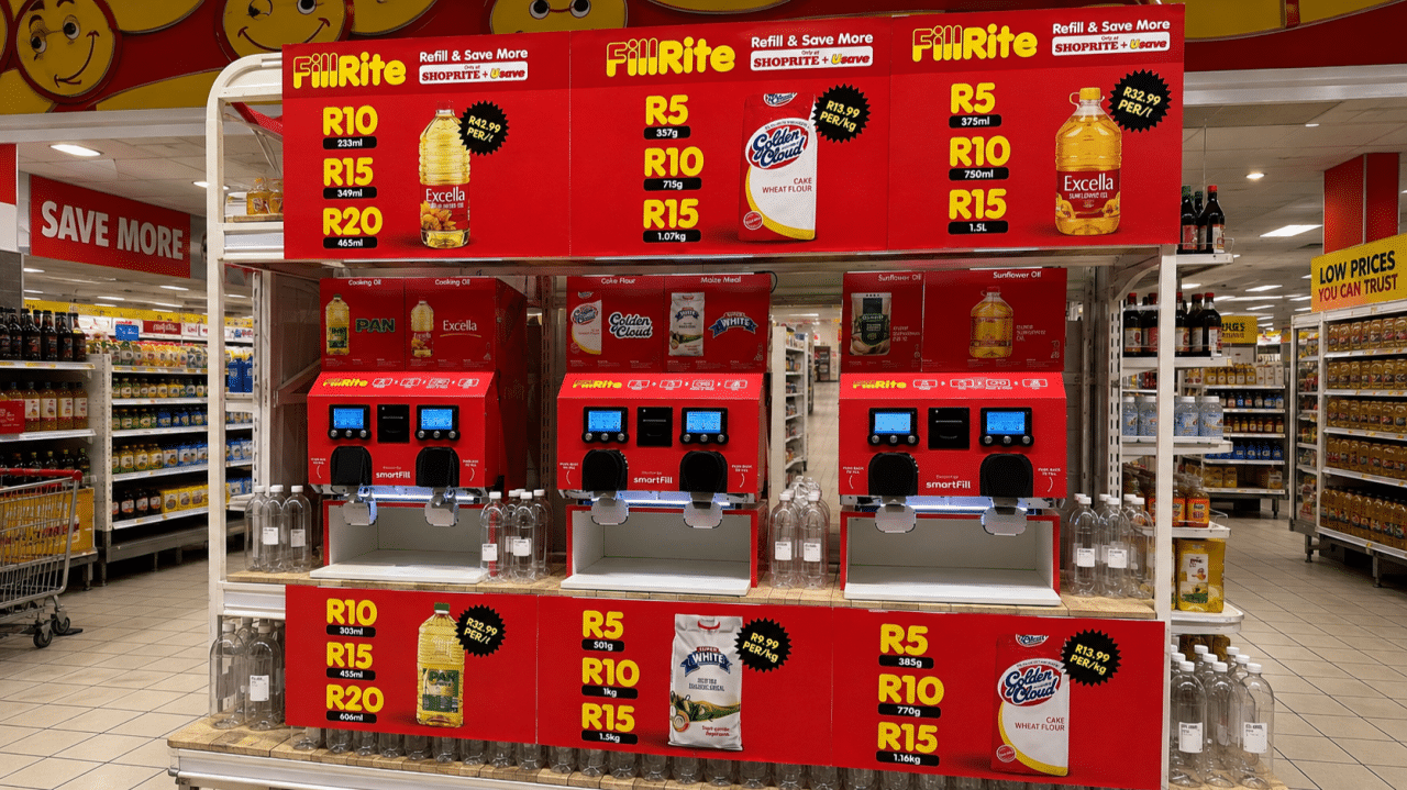 Self serve fillrite beverageoil dispensing station in a grocery store with red price boards showing rr