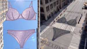 Lavender lingerie set hung on wires between buildings against a clear blue sky left street scene with large lingerie shaped shadows on the road and crosswalk right