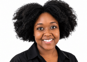 Portrait of a smiling black woman with a curly afro hairstyle wearing a black collared shirt looking at the camera against a white background