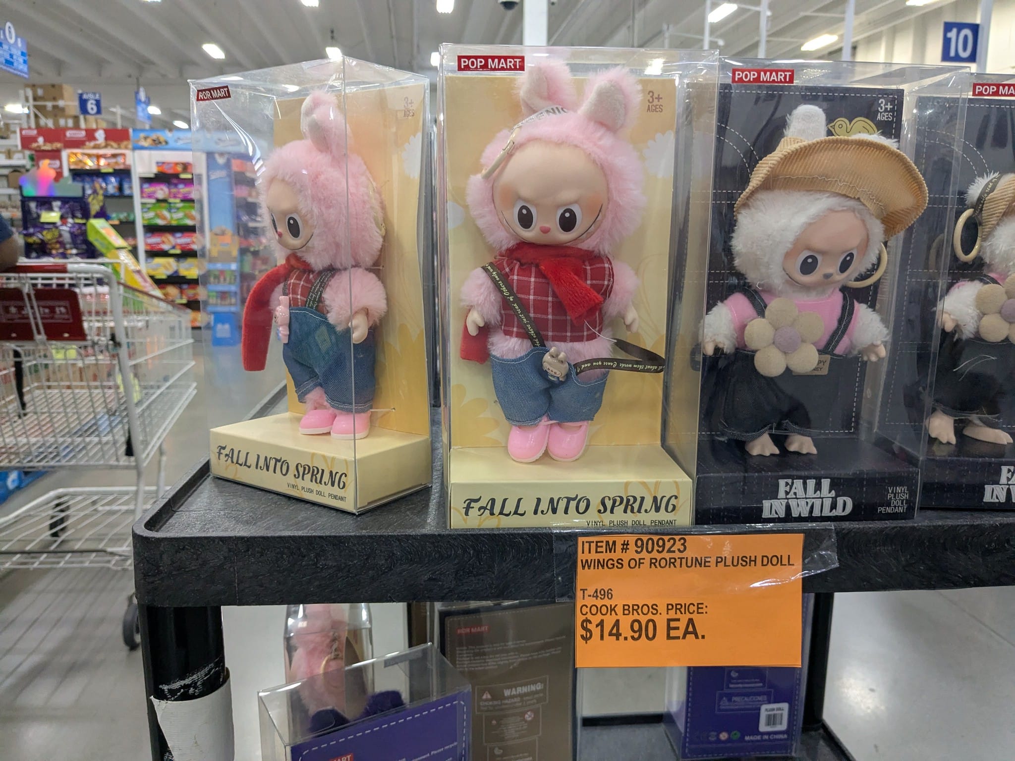 Row of boxed plush bunny dolls on a store shelf with pink fur and colorful outfits