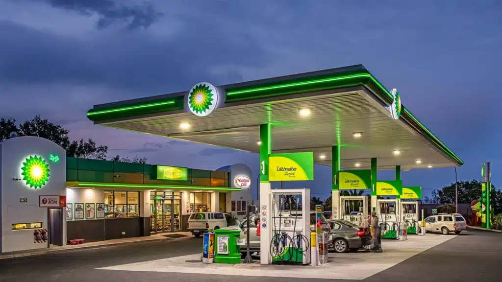 BP gas station at dusk with green canopy, pumps, and a convenience store showing the Wild Bean Cafe sign.