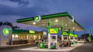 Bp gas station at dusk with green canopy pumps and a convenience store showing the wild bean cafe sign