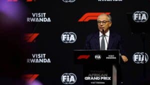 Speaker at a formula  event podium with fia logos and 'visit rwanda' branding