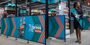 Checkout lane with blue xpress panels and a cart graphic branded 'xpress smart trolley' at a supermarket